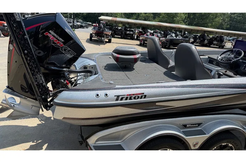 Slide: The Image of 2024 Triton 21 TrX Patriot boat with Mercury Pro XS engine, parked outdoors. - 8