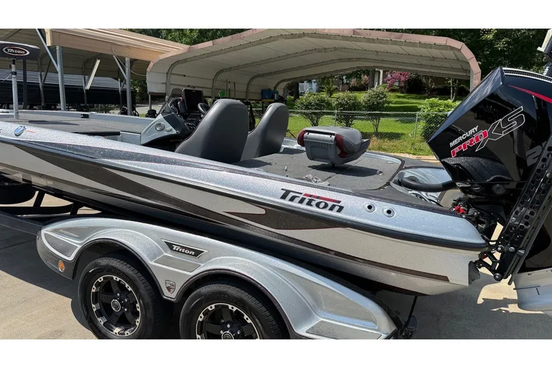 Slide: The Image of 2024 Triton 21 TrX Patriot boat with Mercury Pro XS engine, parked outdoors. - 6