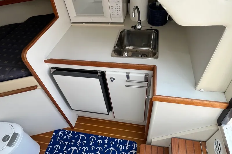 Slide: The Image of Compact galley in 2001 Tiara Yachts 2900 Coronet with sink, fridge, and microwave. - 25