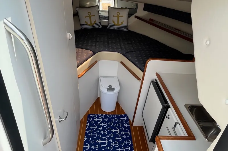Slide: The Image of 2001 Tiara Yachts 2900 Coronet cabin interior with bed, kitchenette, and nautical decor. - 24