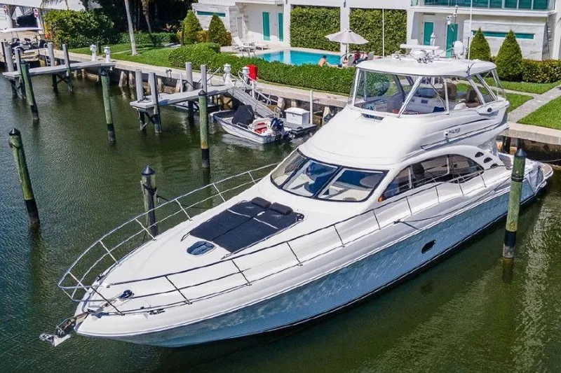 The Image of 2013 Sea Ray 580 Sedan Bridge yacht docked near waterfront property. - 0