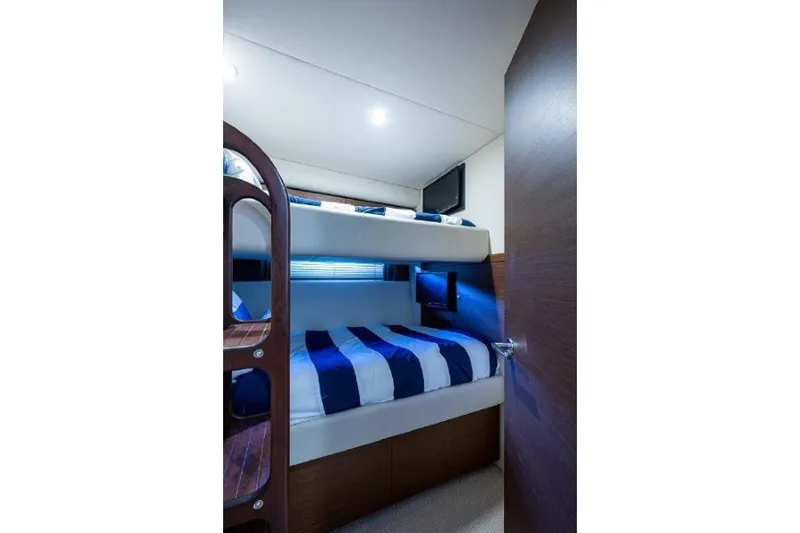 Slide: The Image of Bunk beds in 2013 Sea Ray 580 Sedan Bridge yacht cabin with striped bedding. - 11