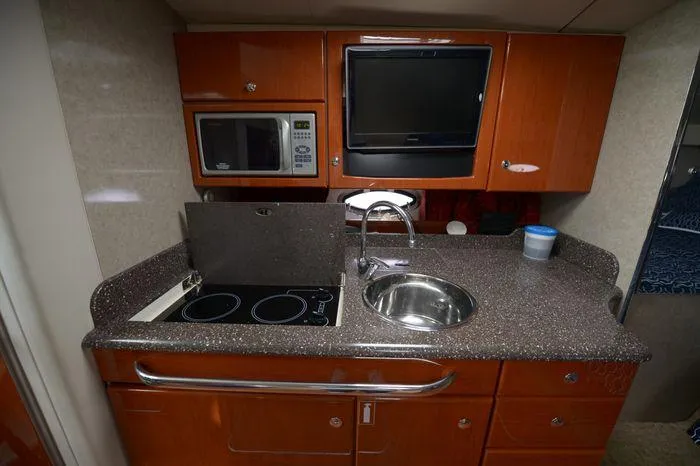 Slide: The Image of 2007 Formula 34 PC yacht kitchen with stove, sink, microwave, and TV. - 24