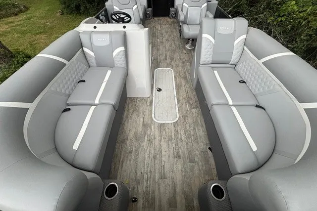Slide: The Image of 2023 Crest Classic DLX 220 pontoon boat interior with gray seating and wood-style flooring. - 13