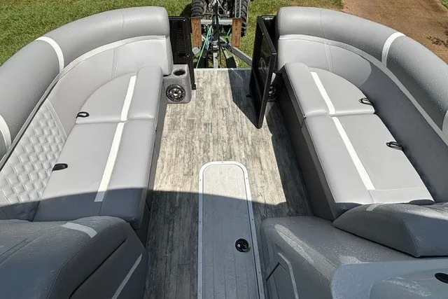 Slide: The Image of 2023 Crest Classic DLX 220 boat interior with gray seating and wood-style flooring. - 24