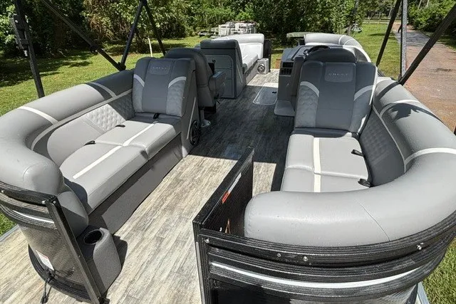 Slide: The Image of 2023 Crest Classic DLX 220 pontoon boat with spacious gray seating and modern design. - 22