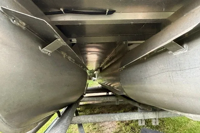 Slide: The Image of Underneath view of a 2023 Crest Classic DLX 220 pontoon boat on a trailer. - 7