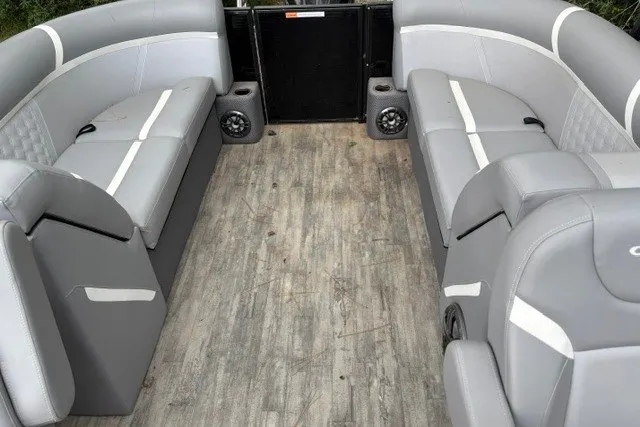 Slide: The Image of 2023 Crest Classic DLX 220 pontoon boat interior with gray seating and wood-style flooring. - 10