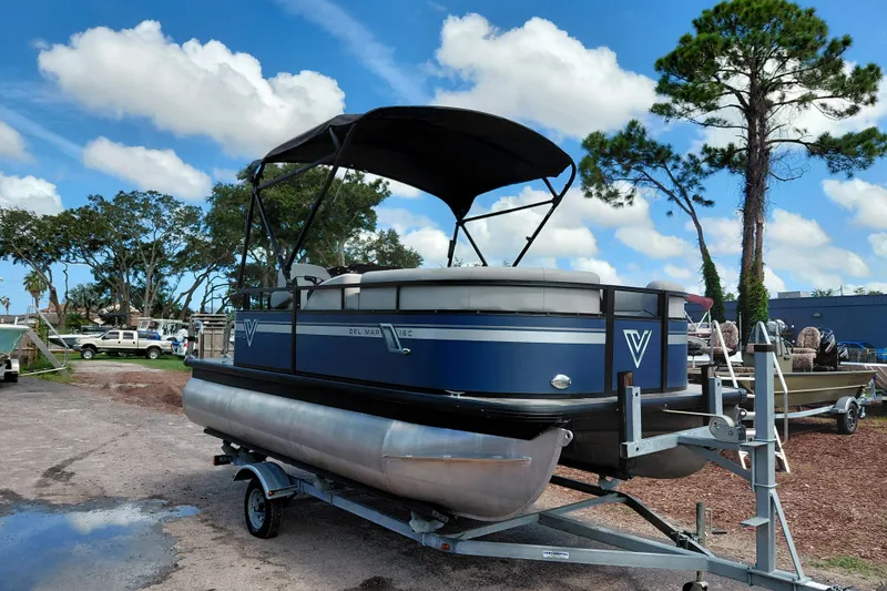 The Image of 2023 Viaggio Del Mar C pontoon boat on trailer, under blue sky with trees. - 1