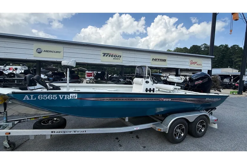 The Image of 2022 Ranger RB200 boat on trailer at dealership, featuring Mercury engine and blue hull. - 1