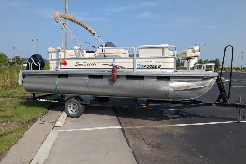 The Image of 2009 Sun Tracker Party Barge 20 Classic pontoon boat on trailer in parking lot. - 1