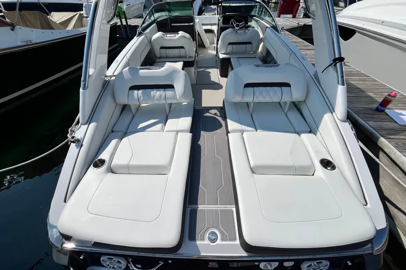 Slide: The Image of 2023 Regal LS6 boat with luxurious white seating and sleek design at a marina. - 12