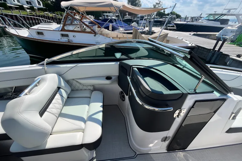 Slide: The Image of 2023 Regal LS6 boat interior with luxurious seating at a marina. - 7
