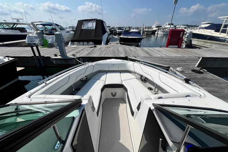 Slide: The Image of 2023 Regal LS6 boat docked at marina, featuring spacious seating and modern design. - 2