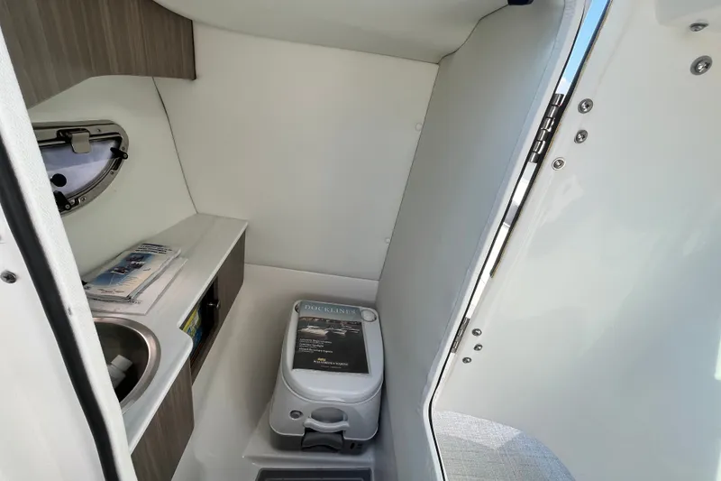 Slide: The Image of 2023 Regal LS6 boat interior with compact bathroom, sink, and storage. - 8
