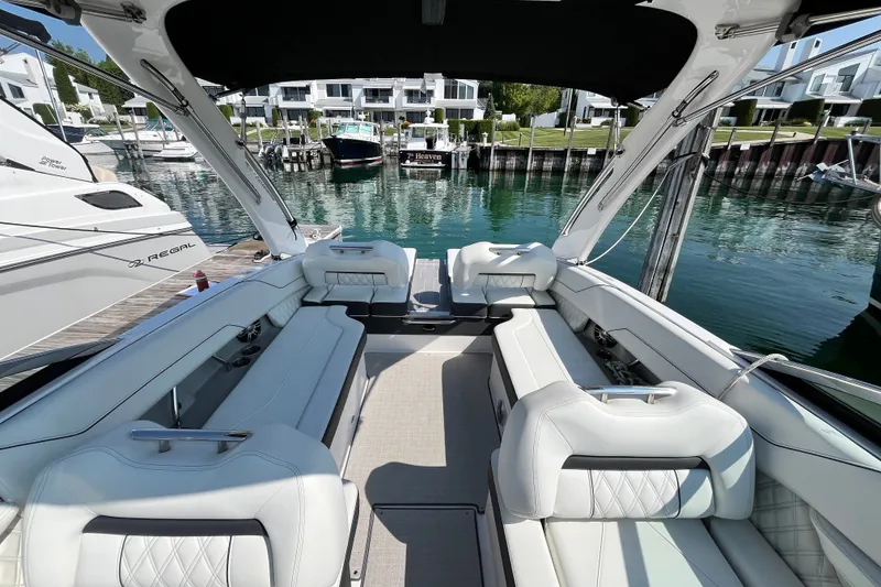 Slide: The Image of Luxurious 2023 Regal LS6 boat interior with white seating, docked at a marina. - 13