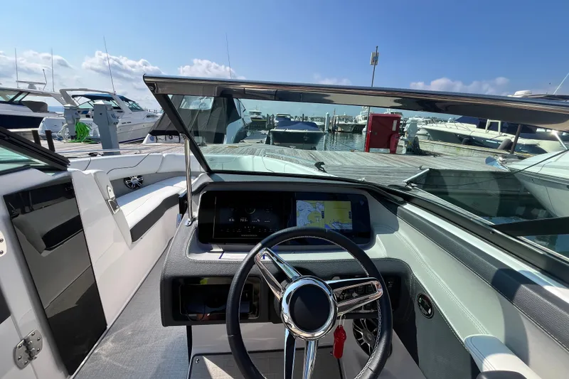 Slide: The Image of 2023 Regal LS6 boat dashboard with steering wheel and navigation display at marina. - 5