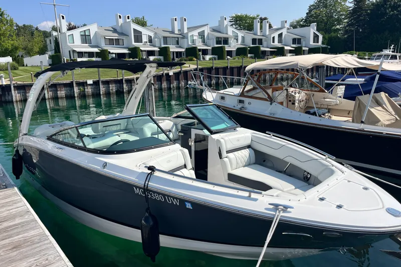 The Image of 2023 Regal LS6 boat docked near modern waterfront homes. - 0