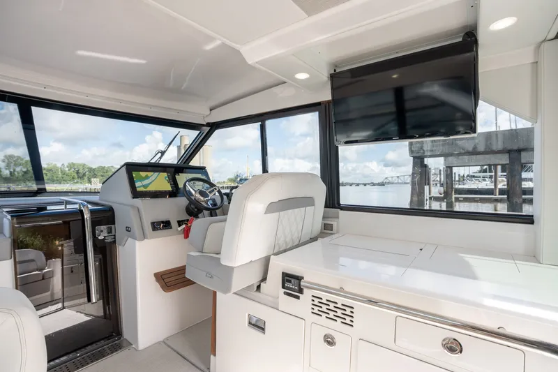 Slide: The Image of Interior of 2025 Regal 36 Grande Coupe yacht with modern helm and panoramic windows. - 31