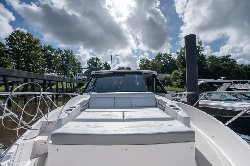 Slide: The Image of 2025 Regal 36 Grande Coupe yacht docked under a cloudy sky. - 20