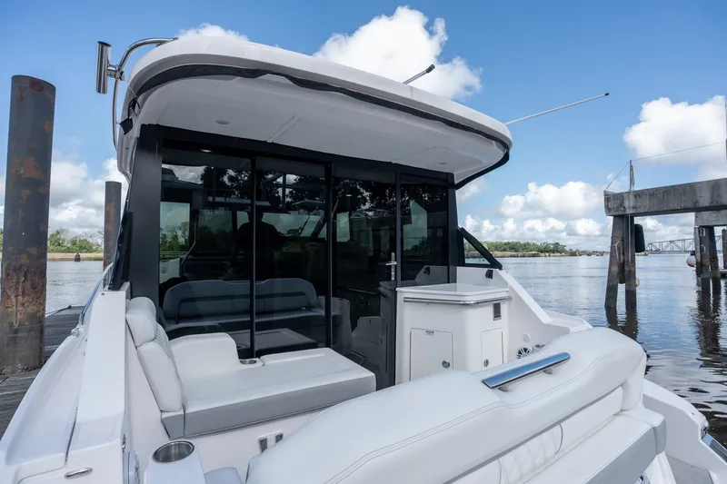 Slide: The Image of 2025 Regal 36 Grande Coupe yacht docked, featuring sleek design and luxurious seating. - 12