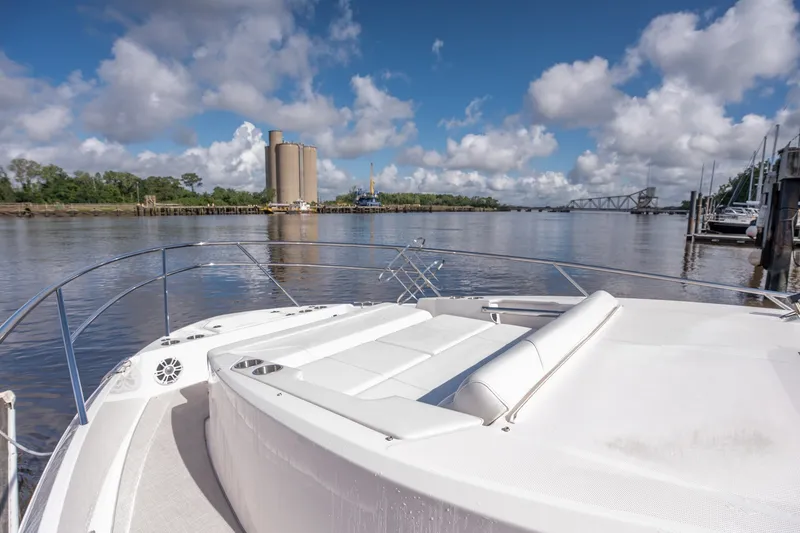 Slide: The Image of 2025 Regal 36 Grande Coupe yacht on calm waters, featuring a spacious deck and scenic view. - 21