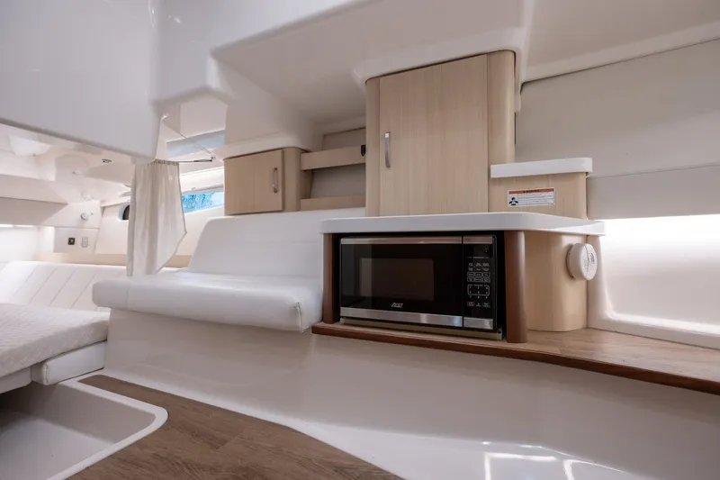 Slide: The Image of Interior of 2025 Regal 36 Grande Coupe featuring modern kitchenette with microwave and seating area. - 46