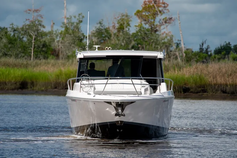 Slide: The Image of 2025 Regal 36 Grande Coupe cruising on a serene waterway, surrounded by lush greenery. - 9
