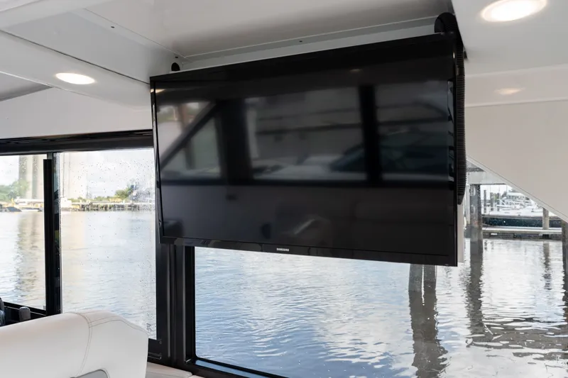 Slide: The Image of Flat-screen TV inside 2025 Regal 36 Grande Coupe yacht with waterfront view. - 27