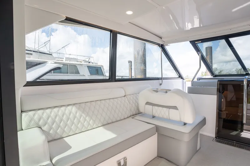 Slide: The Image of Interior of 2025 Regal 36 Grande Coupe yacht with elegant seating and large windows. - 30