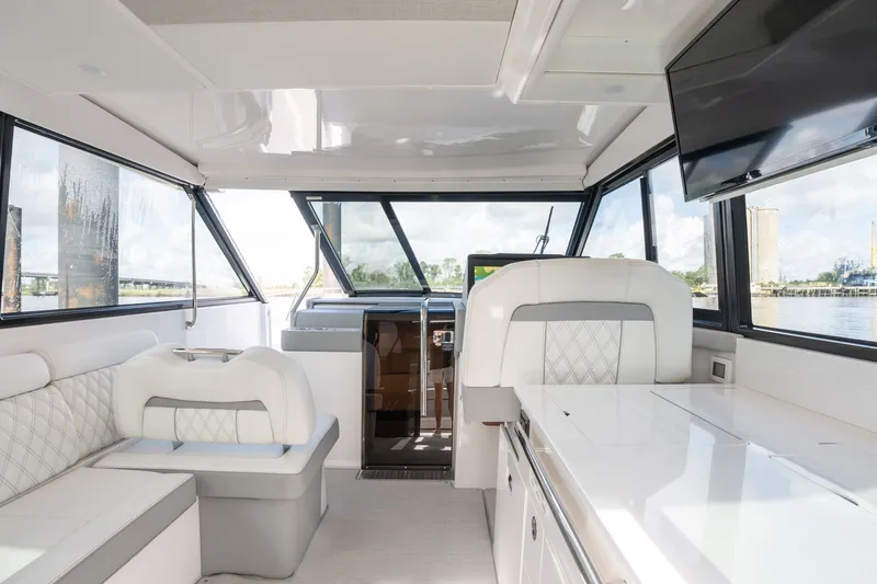 Slide: The Image of Interior of 2025 Regal 36 Grande Coupe yacht with luxurious seating and panoramic windows. - 38