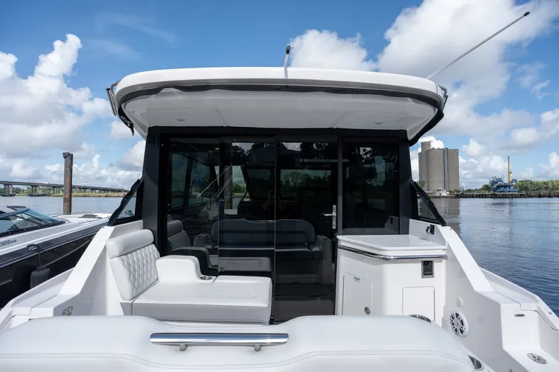 Slide: The Image of 2025 Regal 36 Grande Coupe yacht with sleek design, docked by the waterfront. - 13