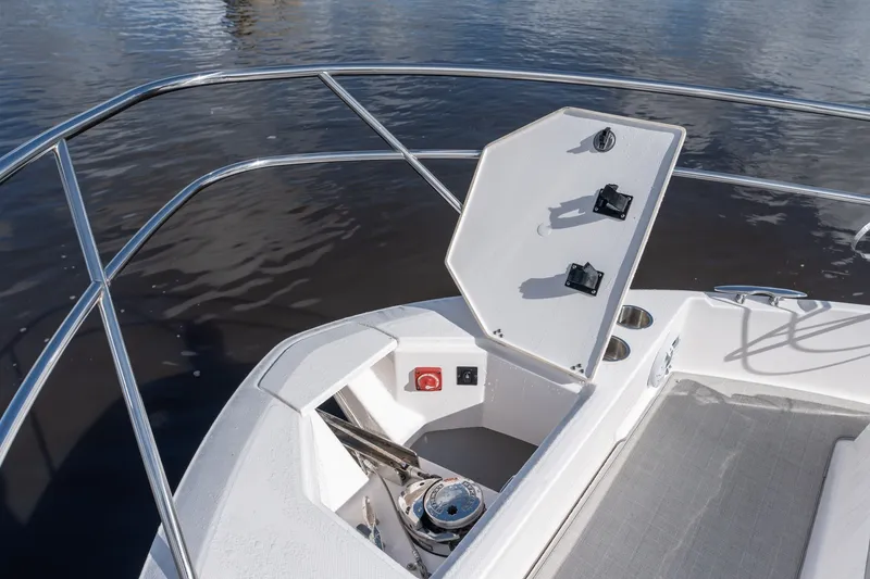 Slide: The Image of 2025 Regal 36 Grande Coupe bow with open anchor hatch on calm water. - 22