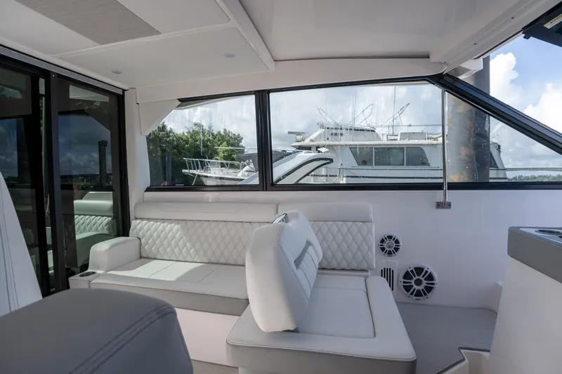 Slide: The Image of Luxurious interior of 2025 Regal 36 Grande Coupe yacht with elegant seating and large windows. - 36