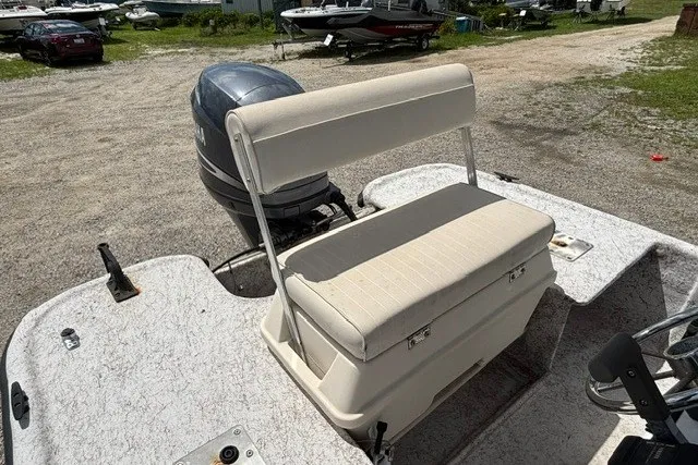 Slide: The Image of 2001 Polar 1780 Flat boat with cushioned seating and outboard motor in a gravel lot. - 13