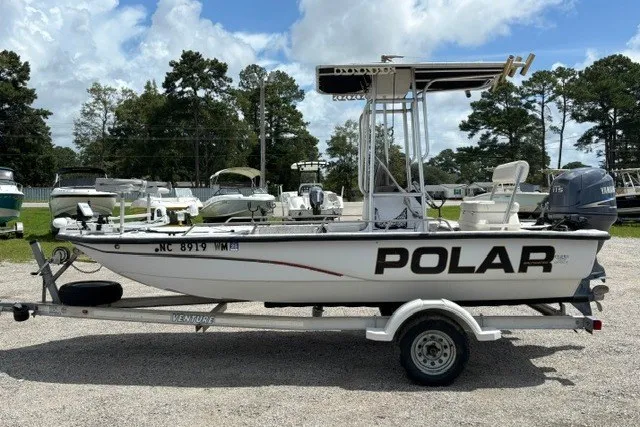 Slide: The Image of 2001 Polar 1780 Flat boat on trailer, parked outdoors under a cloudy sky. - 6