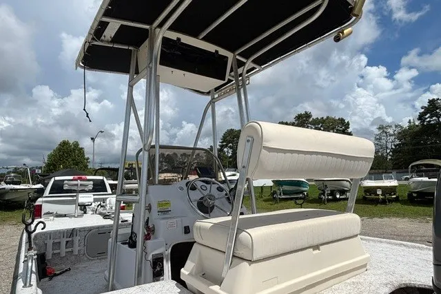 Slide: The Image of 2001 Polar 1780 Flat boat with T-top and seating, parked outdoors under cloudy sky. - 9