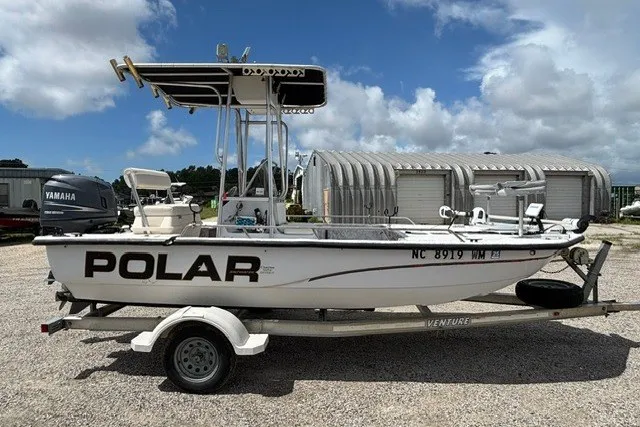 Slide: The Image of 2001 Polar 1780 Flat boat on trailer, parked outdoors under a cloudy sky. - 5