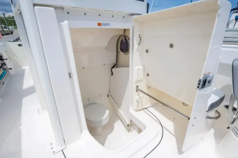 Slide: The Image of 2021 Robalo R272 Center Console boat with open bathroom compartment. - 11