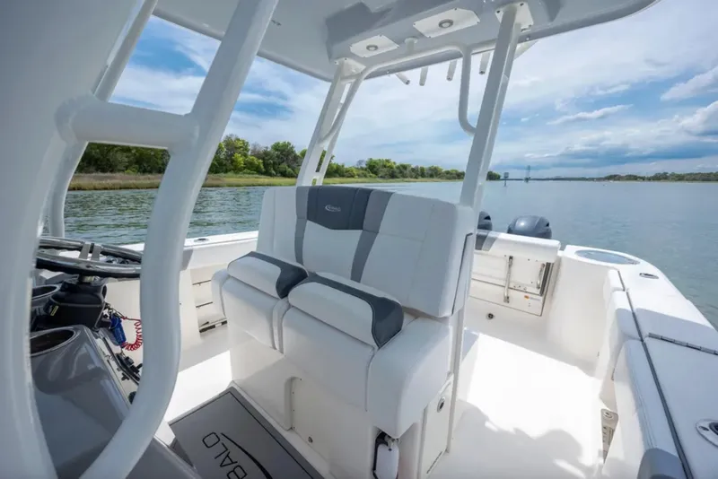 Slide: The Image of 2021 Robalo R272 Center Console boat interior with seating, on a calm lake. - 7