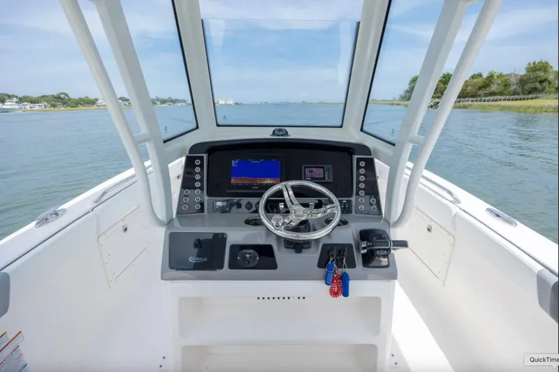 Slide: The Image of 2021 Robalo R272 Center Console boat helm with steering wheel and navigation display. - 16