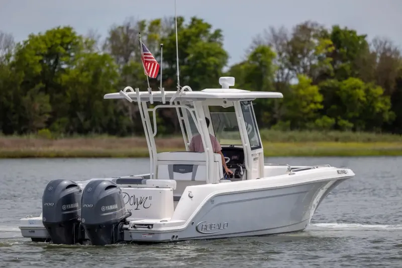 Slide: The Image of 2021 Robalo R272 Center Console boat cruising on a lake with dual Yamaha engines. - 1