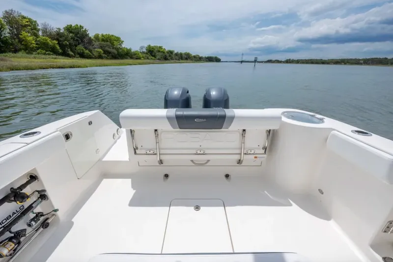 Slide: The Image of 2021 Robalo R272 Center Console boat on calm water, showcasing spacious deck and dual engines. - 5