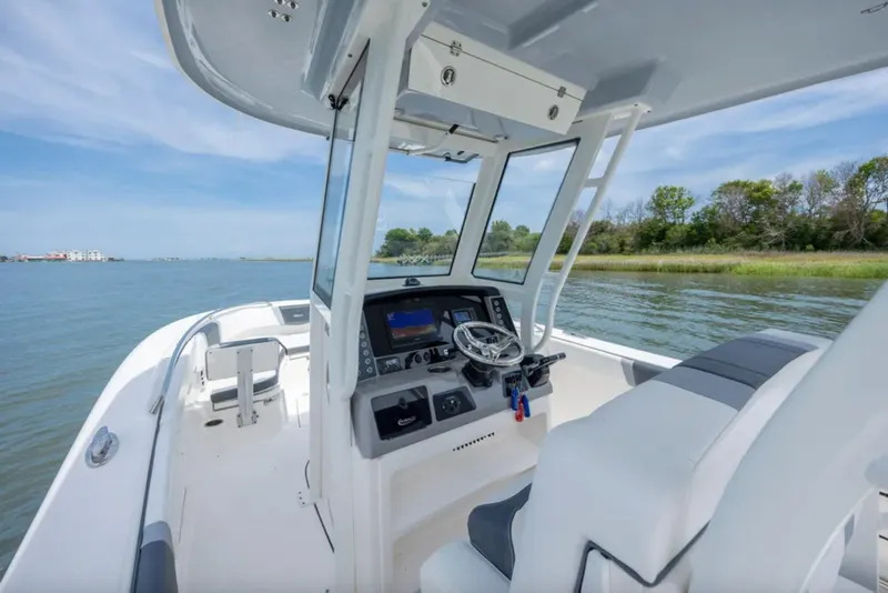 Slide: The Image of 2021 Robalo R272 Center Console boat interior with steering wheel and navigation system. - 8