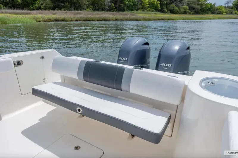 Slide: The Image of 2021 Robalo R272 Center Console boat with dual 200 horsepower engines on a serene lake. - 18