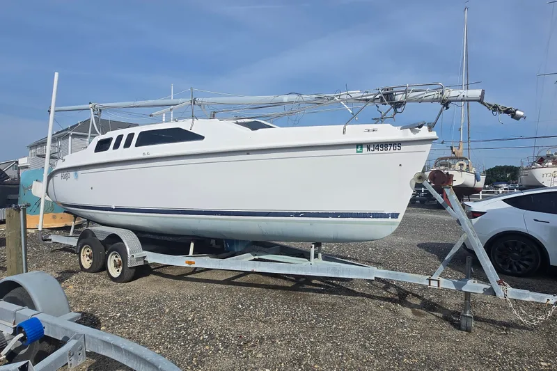 The Image of 2001 Hunter 26 sailboat on trailer in a marina setting. - 0