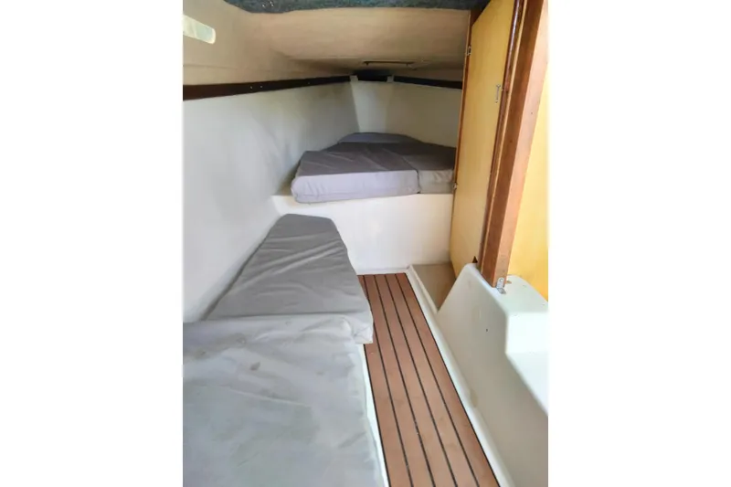 Slide: The Image of Interior cabin of a 1980 MacGregor 25 sailboat with cushioned seating and wooden flooring. - 10