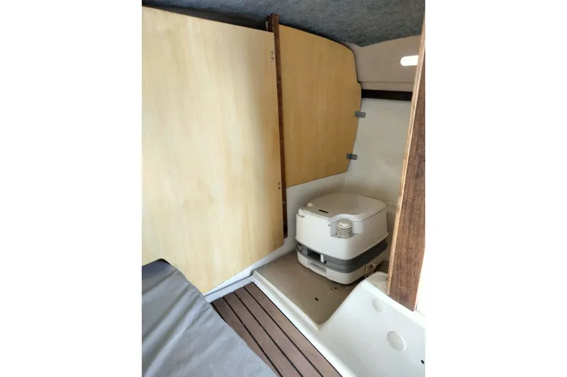 Slide: The Image of Interior of a 1980 MacGregor 25 sailboat featuring a compact marine toilet. - 9