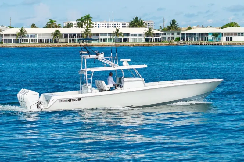 Slide: The Image of 2026 Contender 44 ST boat cruising on blue water near coastal buildings. - 12