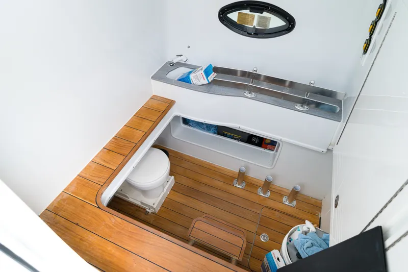 Slide: The Image of 2026 Contender 44 ST boat interior with wooden flooring and compact bathroom amenities. - 36